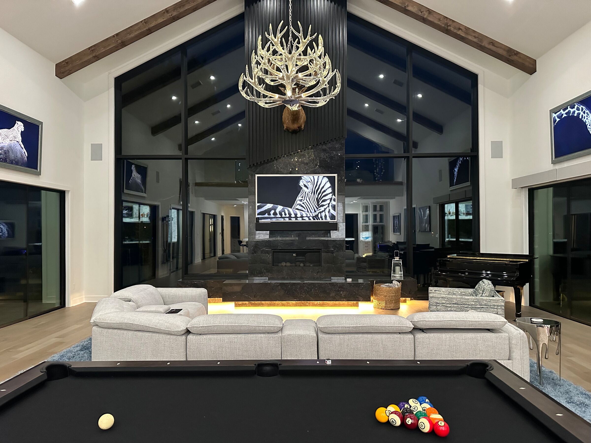 Great room with a vaulted ceiling, display wall and billiards table