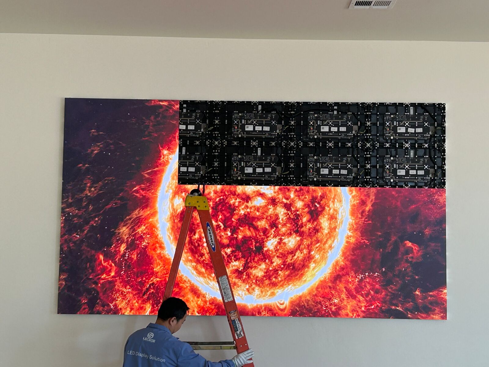 Technician installing an LED video wall panel by panel