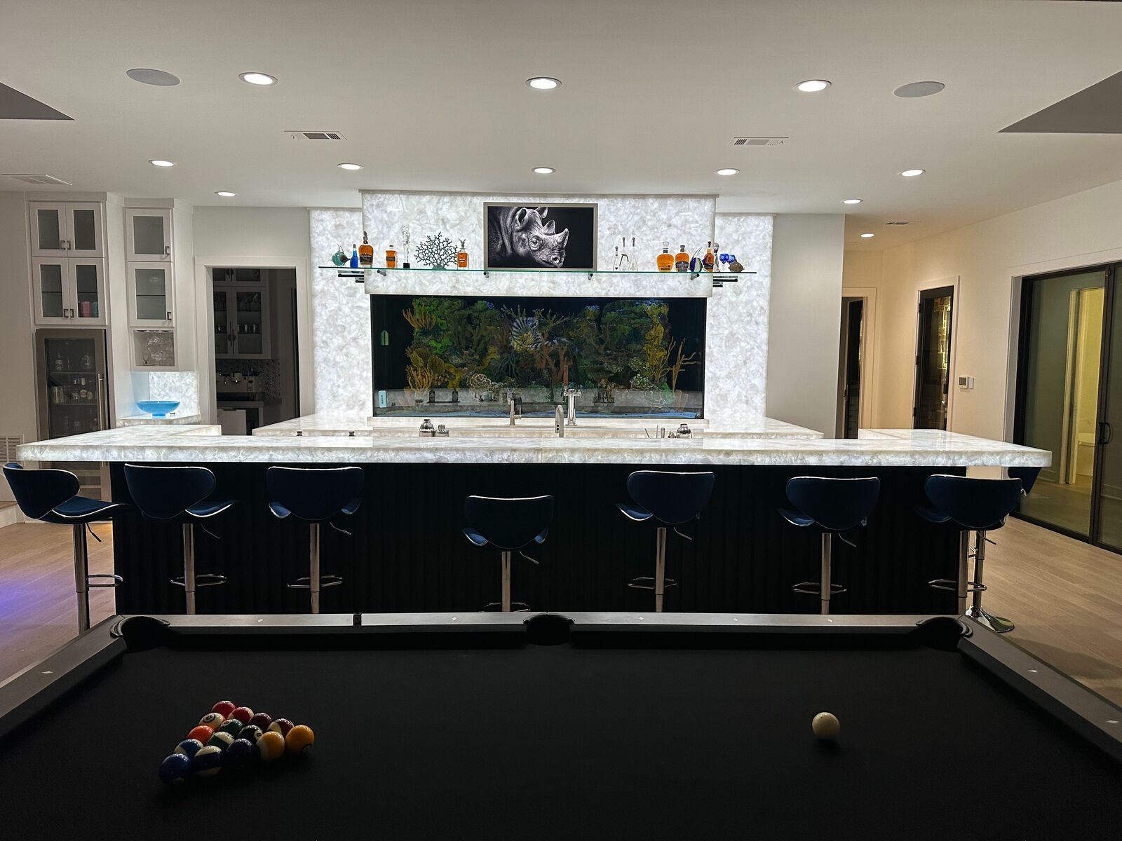Entertainment bar and game room with ceiling speakers and a display above the bar